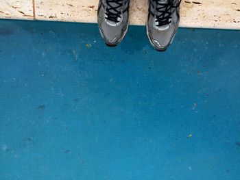 Low section of man standing on tiled floor