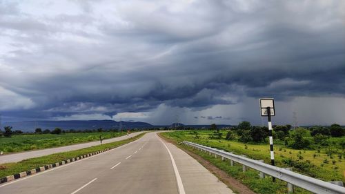 Empty road against cloudy sky