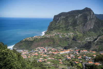 Scenic view of sea and buildings against clear sky