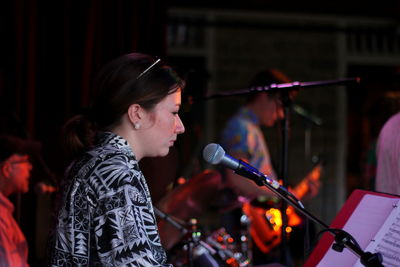 Young woman with arms raised in music concert