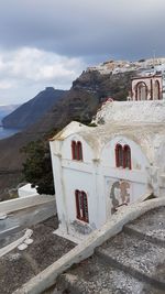 Old building by mountains against sky