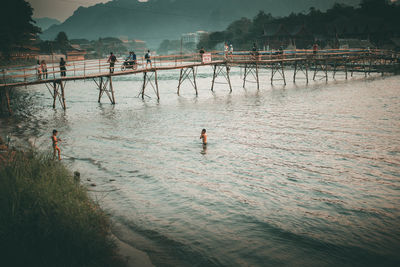 Footbridge over river during sunset