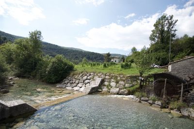 Scenic view of river against cloudy sky