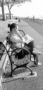 Rear view of woman sitting on road in city