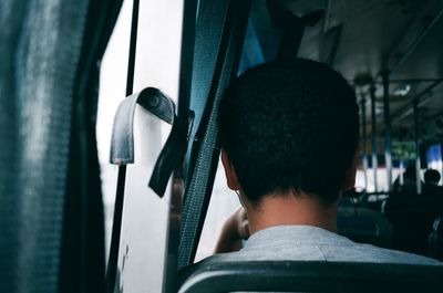 Rear view of man traveling in bus