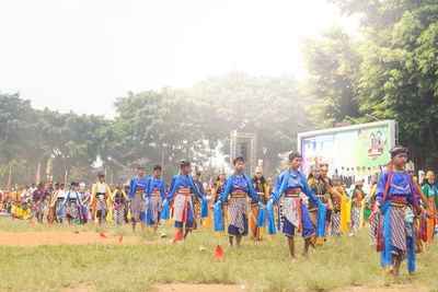 Group of people on field against trees