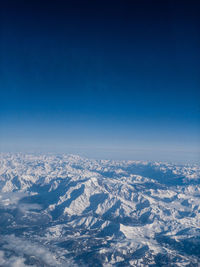 Aerial view of dramatic landscape against blue sky