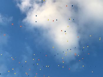 Low angle view of balloons flying against sky