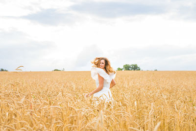 Woman standing on field against sky