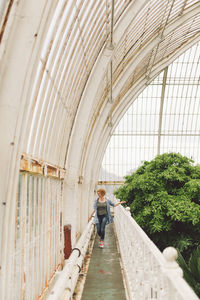 Full length of woman standing in greenhouse