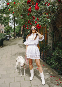 Portrait of young woman with dog on street