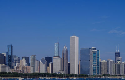 Modern buildings in city against blue sky