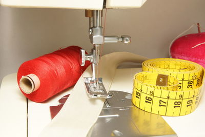 Close-up of spool with tape measure on sewing machine