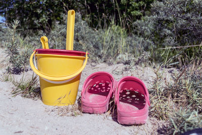 Close-up of yellow and red shoes on sand