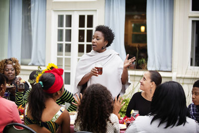 Woman announcing to friends and family at table