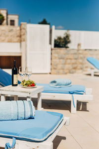 Empty chairs and table by swimming pool