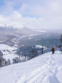 Person skiing on snowcapped mountain against sky