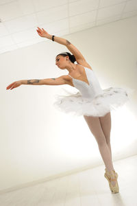 Ballet dancer on pointe with tattooed arms