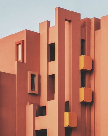 LOW ANGLE VIEW OF ORANGE BUILDING AGAINST SKY