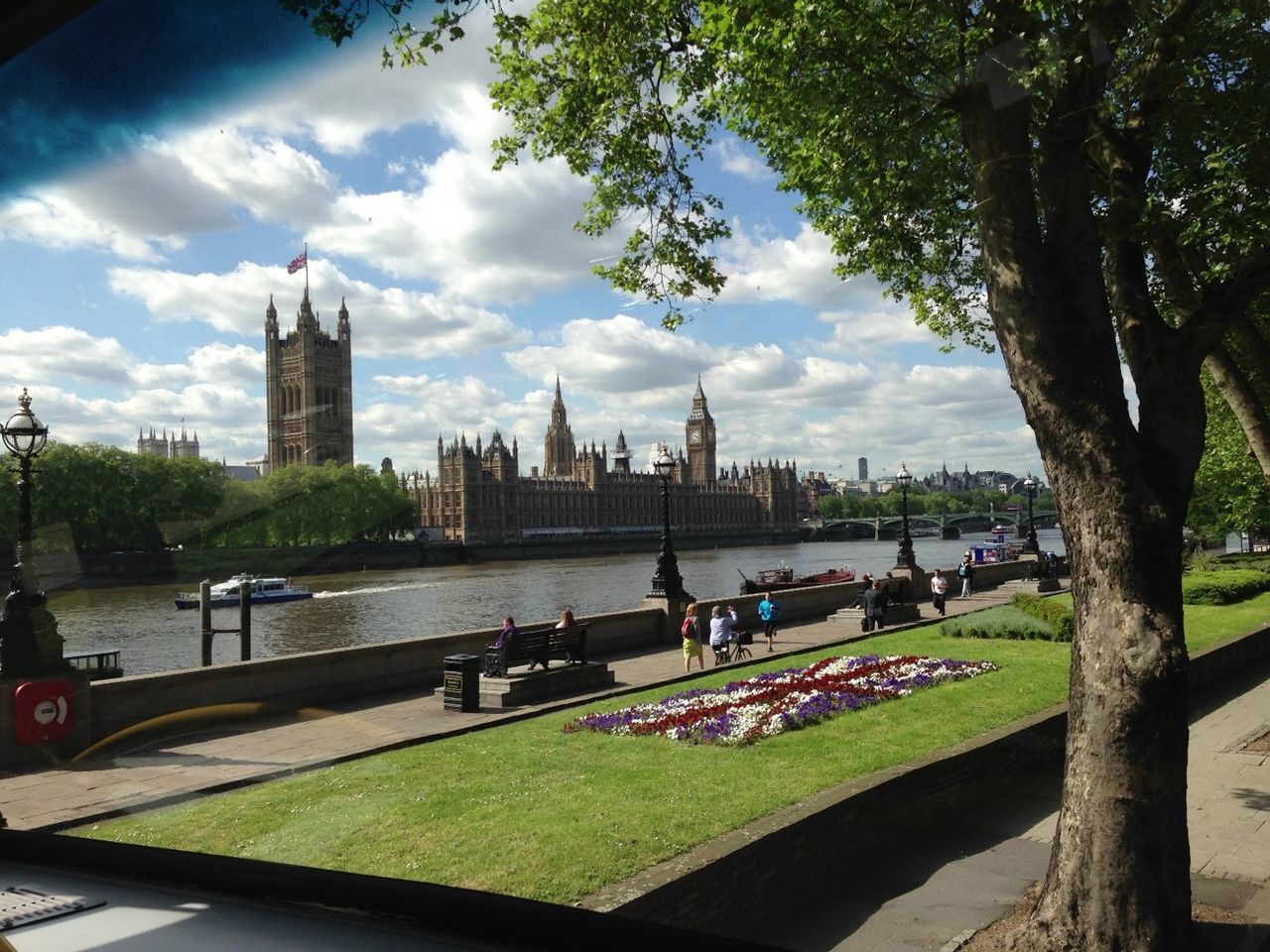 architecture, built structure, building exterior, sky, city, cloud - sky, tree, river, famous place, tower, grass, travel destinations, cloud, water, international landmark, capital cities, travel, transportation, tourism, incidental people