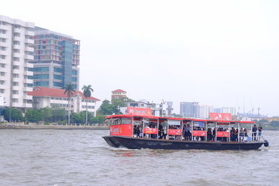 Boat in river against clear sky in city