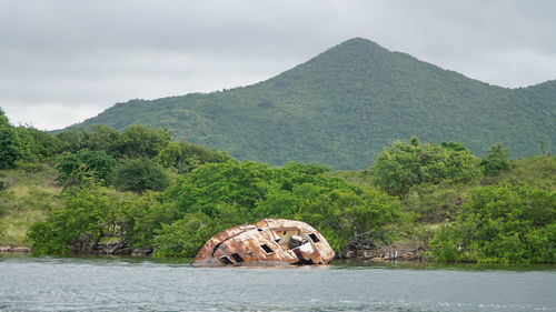 Scenic view of lake by mountains against sky