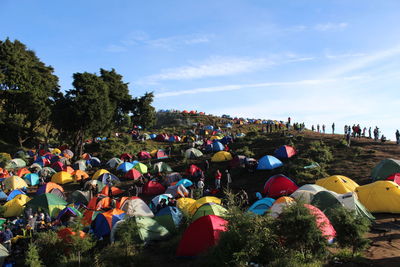 Group of people by plants against sky
