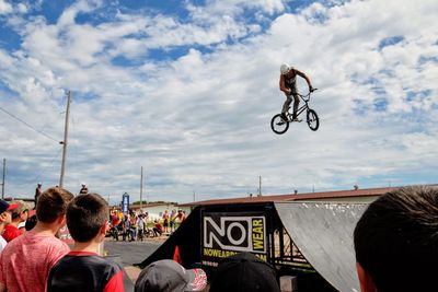People on bicycle against cloudy sky
