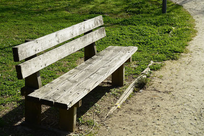 Empty bench on grassy field