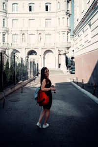 Full length portrait of woman on road in city