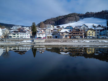 Reflection of buildings in lake against sky