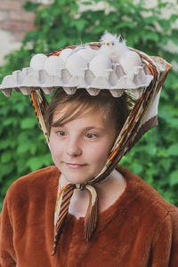 Teenage girl with eggs and chick on her head