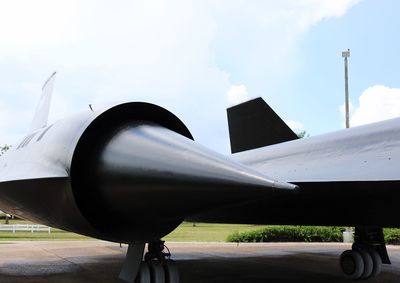 Airplane at airport runway against sky