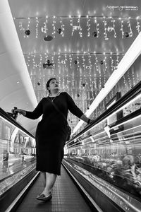 Rear view of woman standing on railing