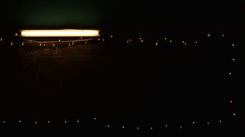 Silhouette people in illuminated city against sky at night