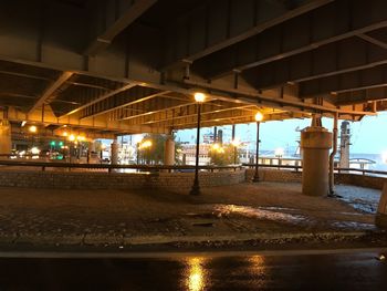 Illuminated road by building at night