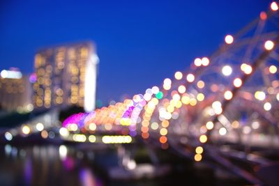 Defocused image of illuminated city against sky at night