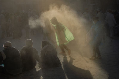 Rear view of woman standing by smoke