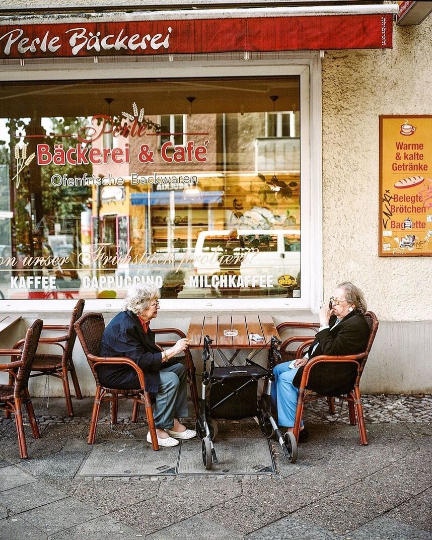 PEOPLE SITTING AT SIDEWALK CAFE