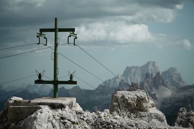 Low angle view of cables on mountain against sky