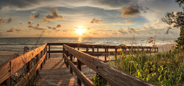 Boardwalk leading toward delnor-wiggins state park at sunset in naples, florida.