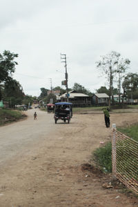 Cars on street by road against sky