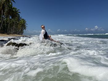 Man in sea against sky