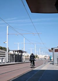 Rear view of man riding a bicycle on road