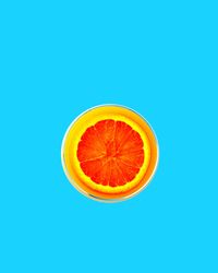 Close-up of orange slice against blue background