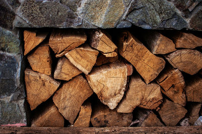  chopped firewood for the fireplace lies in a stone cell for materials for fire.