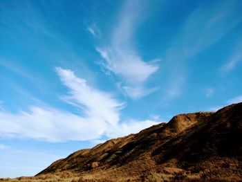 Low angle view of mountain against blue sky