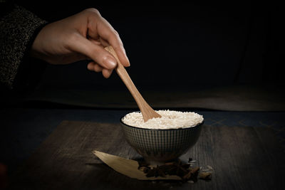 Hand holding ice cream cone on table