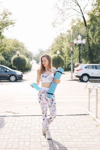 Happy fun healthy athletic girl in sportswear training and exercising in the park in nature outdoors