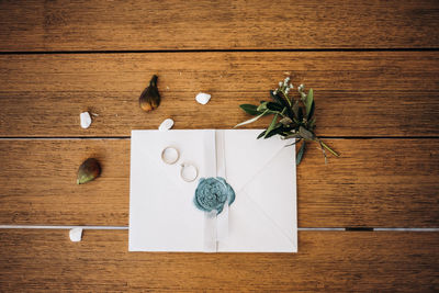 Wedding rings on the wooden table with letter and figs